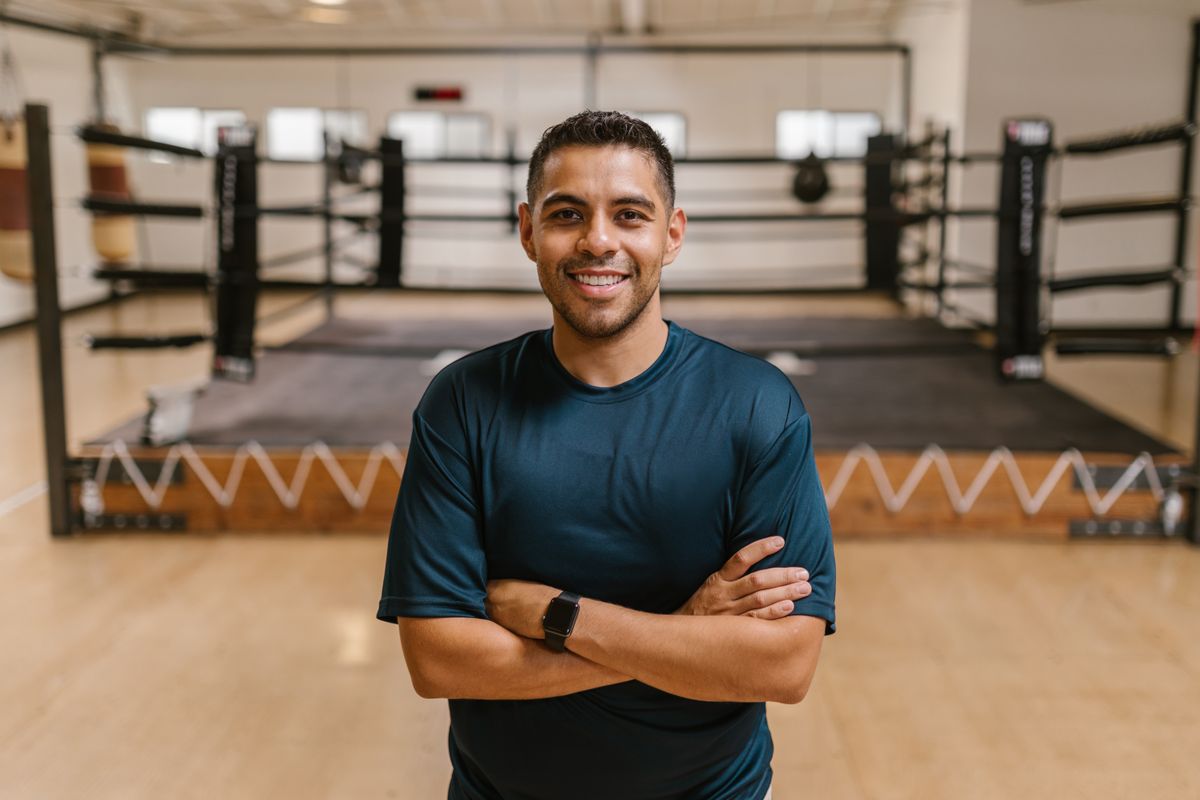 A friendly instructor smiling warmly in a bright, welcoming training space.